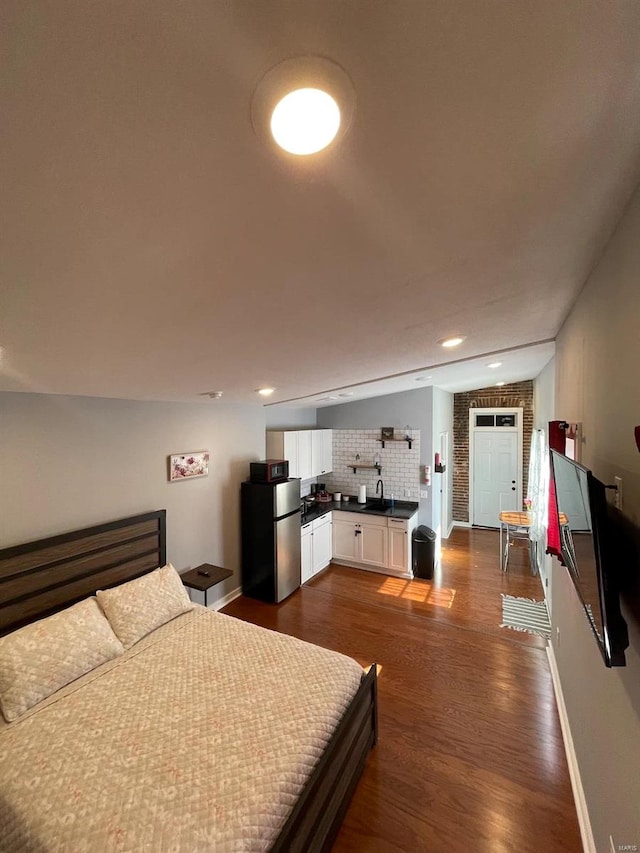 bedroom with baseboards, recessed lighting, freestanding refrigerator, dark wood-style floors, and a sink