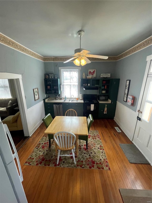 dining space featuring visible vents, baseboards, a ceiling fan, and hardwood / wood-style flooring