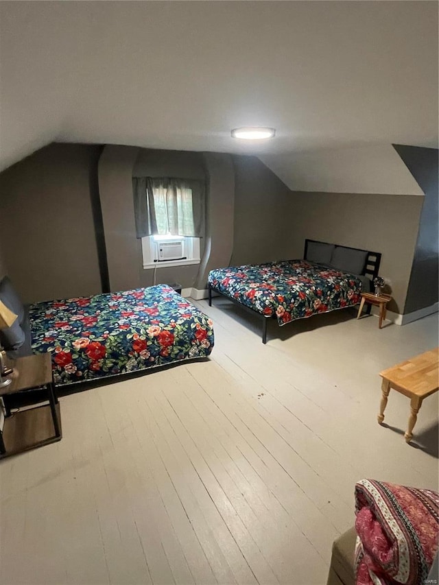 bedroom with vaulted ceiling, cooling unit, and wood finished floors