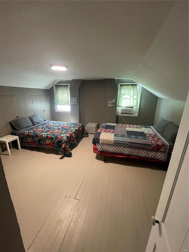 bedroom featuring cooling unit, vaulted ceiling, and hardwood / wood-style flooring