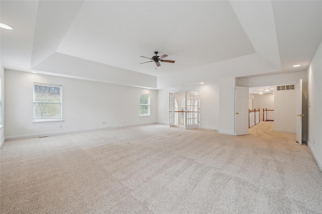 empty room with baseboards, visible vents, and a raised ceiling