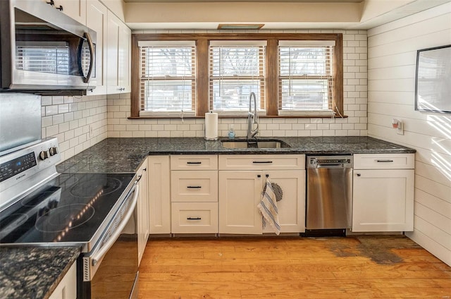 kitchen with appliances with stainless steel finishes, white cabinets, and sink