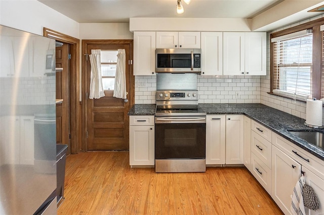 kitchen featuring backsplash, stainless steel appliances, and white cabinetry