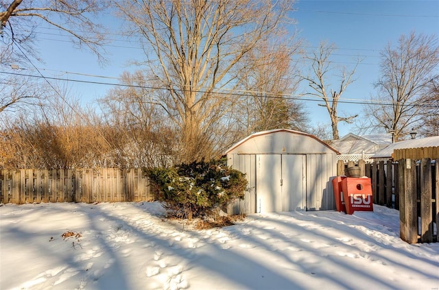 yard layered in snow featuring a storage unit