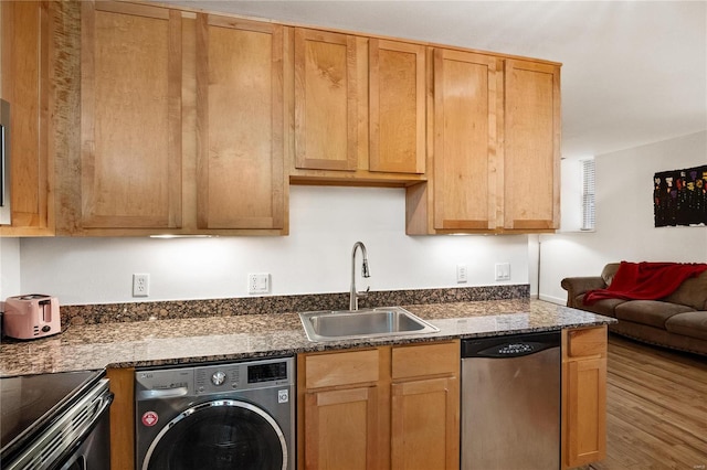 kitchen featuring stainless steel dishwasher, wood-type flooring, washer / clothes dryer, and sink