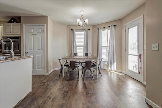 dining room with dark wood-style floors, baseboards, and a notable chandelier