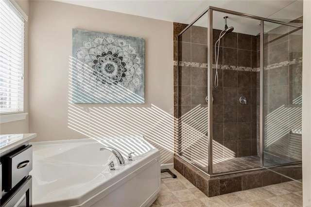 bathroom featuring a stall shower, tile patterned flooring, a bath, and vanity