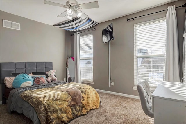 carpeted bedroom with a ceiling fan, visible vents, and baseboards