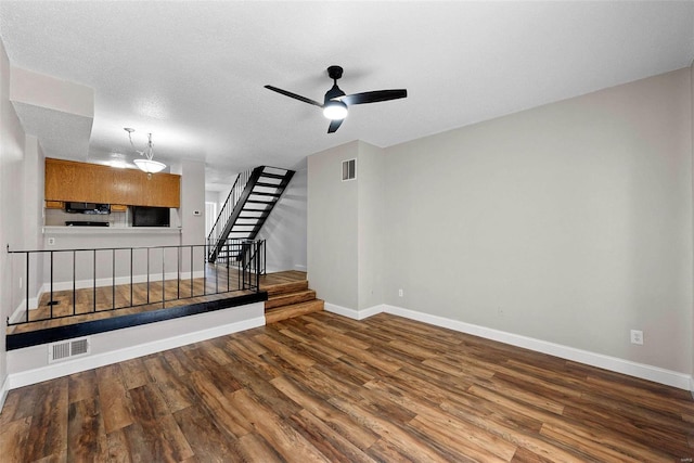 unfurnished living room featuring a textured ceiling, ceiling fan, and hardwood / wood-style flooring