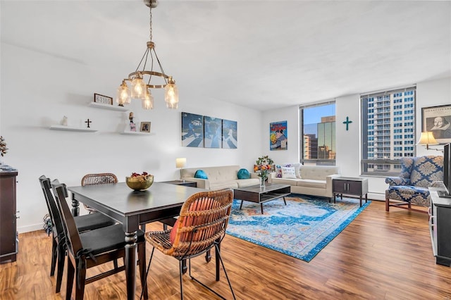 dining space featuring hardwood / wood-style flooring and a chandelier