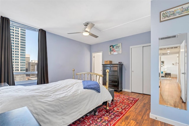 bedroom with a closet, ceiling fan, and dark wood-type flooring