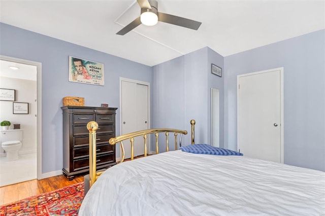 bedroom with a ceiling fan, baseboards, wood finished floors, a closet, and connected bathroom