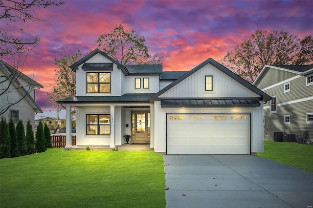 modern farmhouse with a garage, a yard, and covered porch