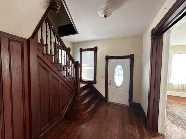 foyer with a healthy amount of sunlight and dark hardwood / wood-style floors