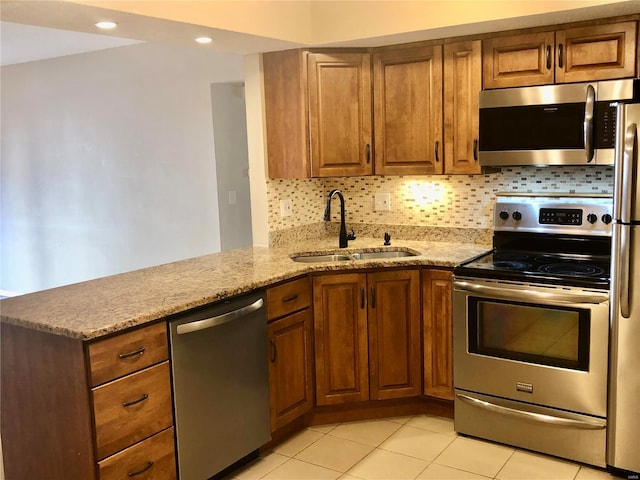 kitchen featuring light stone countertops, sink, appliances with stainless steel finishes, and tasteful backsplash