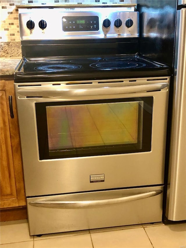 interior details featuring light stone counters and stainless steel electric range oven