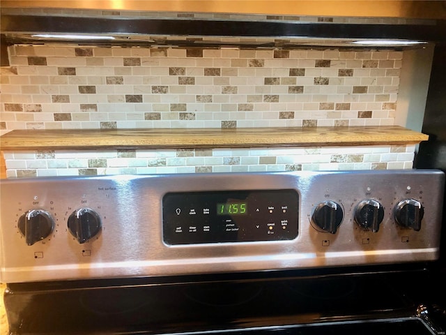 room details featuring stainless steel range oven, extractor fan, and backsplash