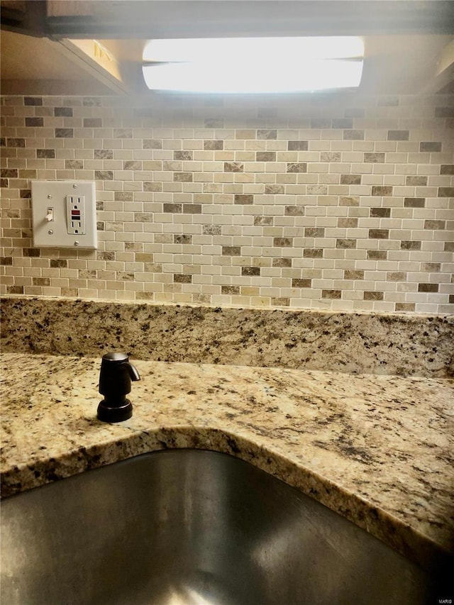 details featuring decorative backsplash and sink