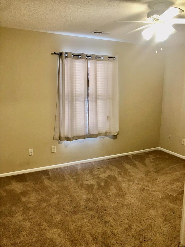 carpeted spare room featuring ceiling fan and a textured ceiling