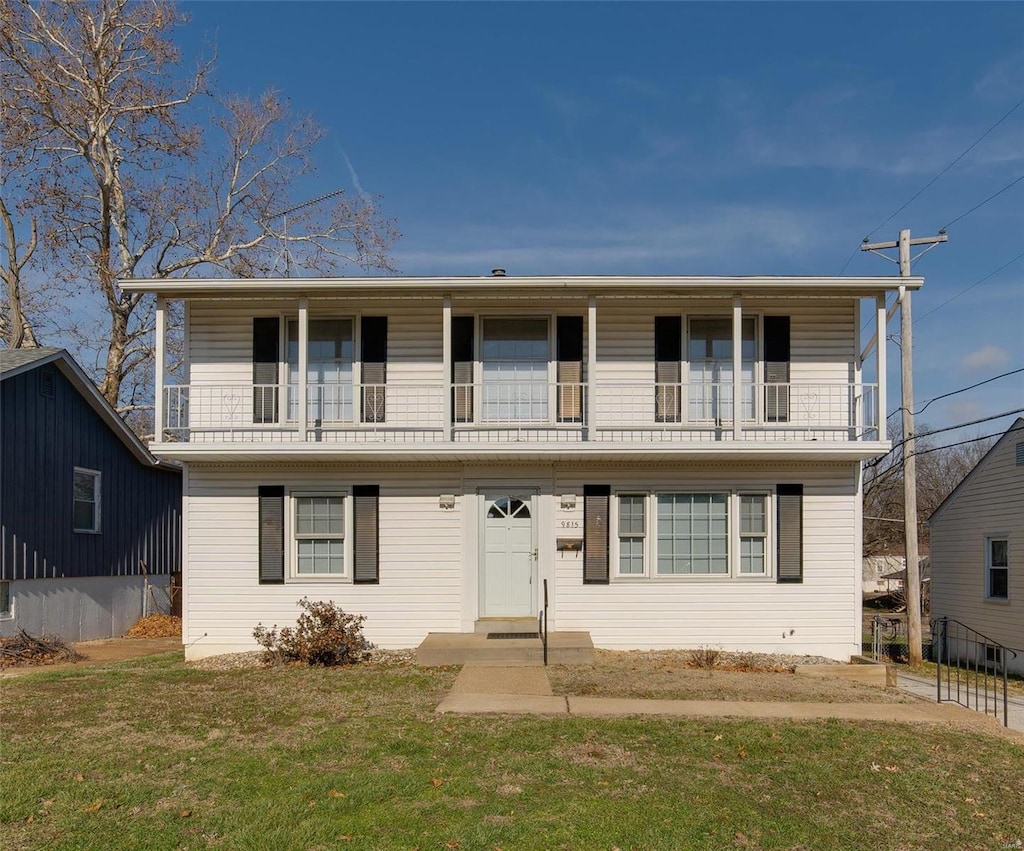 view of front property with a balcony and a front yard