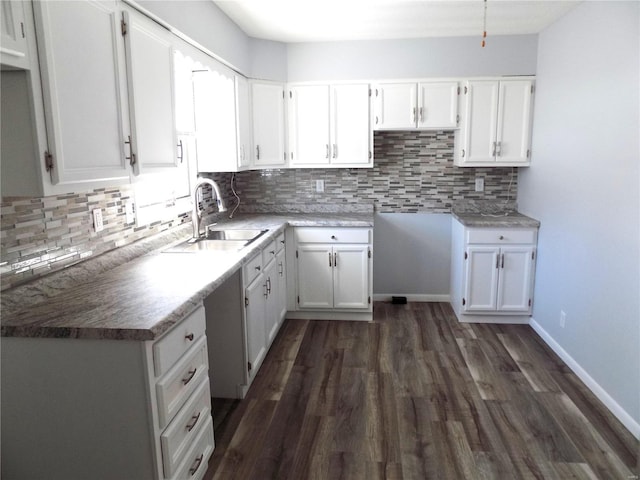 kitchen with sink, white cabinetry, tasteful backsplash, and dark wood-type flooring