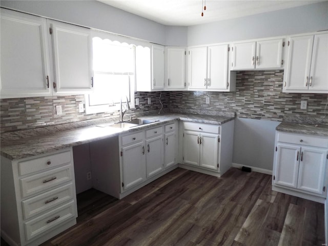 kitchen with sink, white cabinetry, tasteful backsplash, and dark wood-type flooring