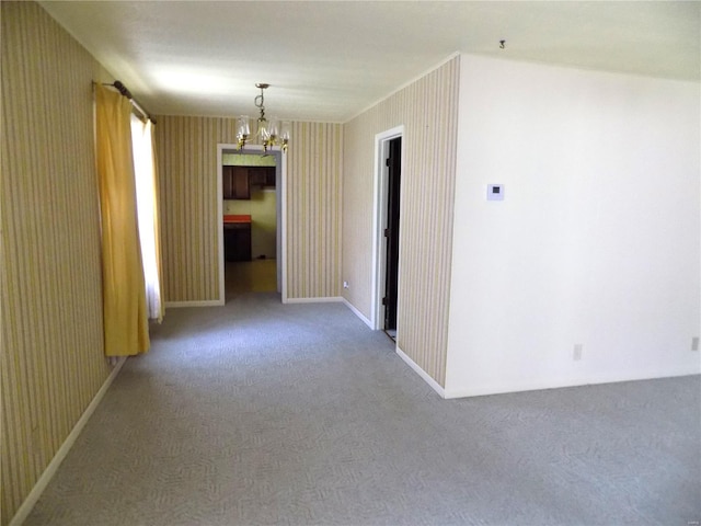 carpeted empty room with a chandelier