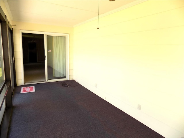 carpeted spare room featuring crown molding