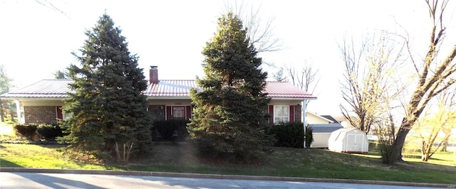 view of front of home with a front yard and a shed