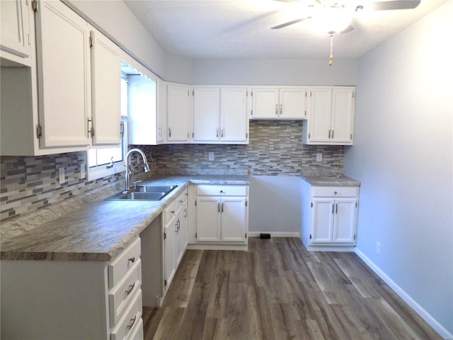 kitchen with tasteful backsplash, sink, dark hardwood / wood-style flooring, and white cabinets