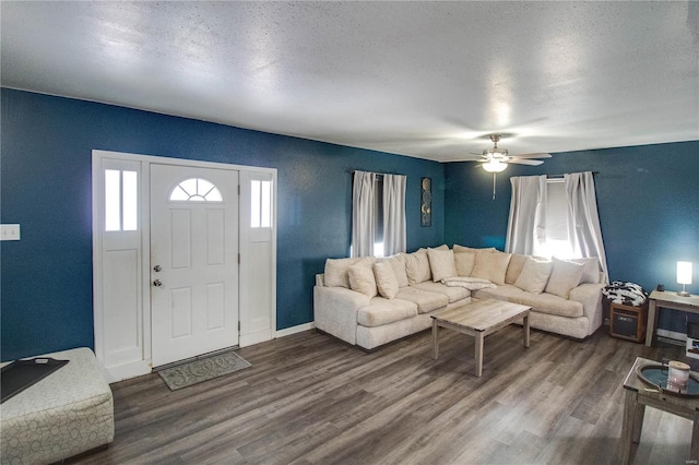 living room featuring ceiling fan, dark hardwood / wood-style flooring, and a textured ceiling