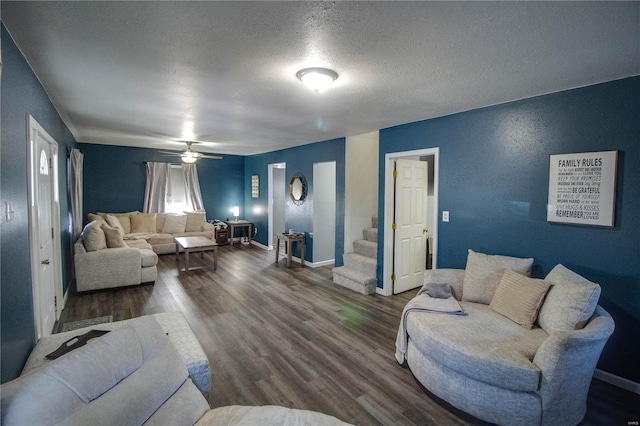 living room featuring a textured ceiling, dark wood-type flooring, and ceiling fan