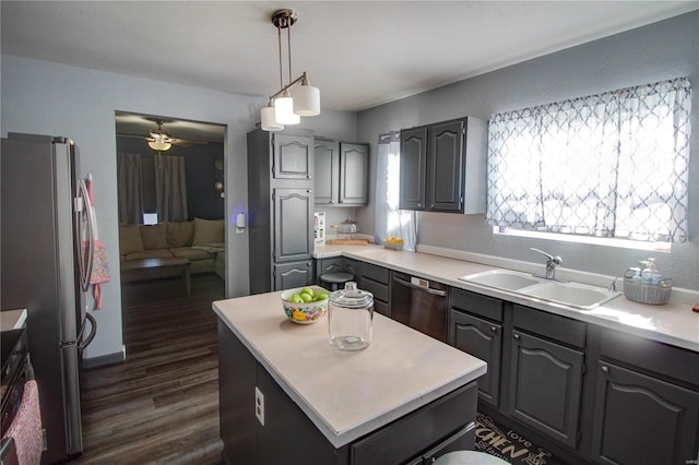 kitchen with a center island, dark hardwood / wood-style flooring, stainless steel appliances, sink, and hanging light fixtures