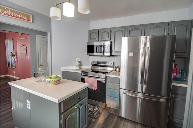 kitchen with gray cabinets, stainless steel appliances, decorative light fixtures, dark wood-type flooring, and a center island