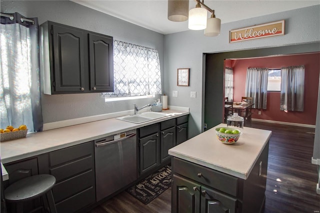 kitchen with dark wood-type flooring, sink, hanging light fixtures, and dishwasher