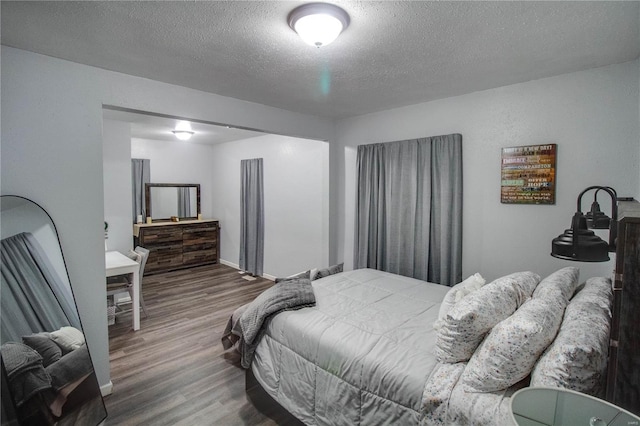 bedroom with a textured ceiling and hardwood / wood-style flooring