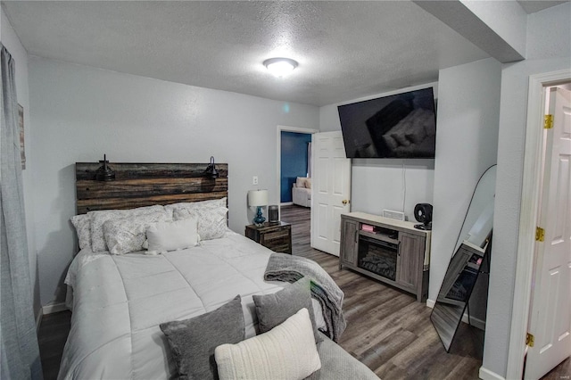 bedroom featuring wood-type flooring and a textured ceiling