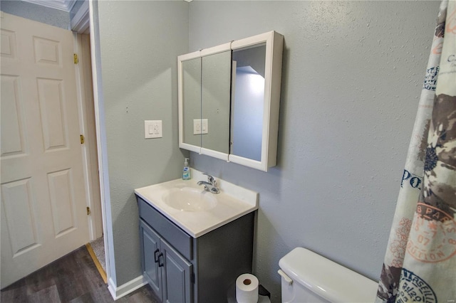 bathroom featuring toilet, hardwood / wood-style floors, and vanity