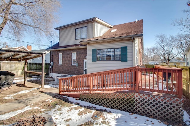 snow covered house with a wooden deck