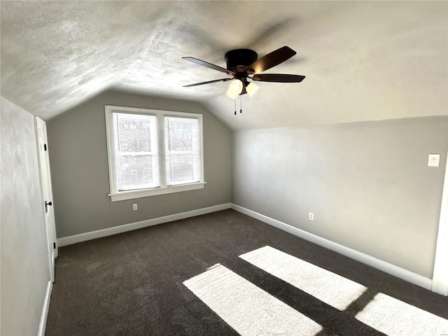 bonus room with lofted ceiling, ceiling fan, a textured ceiling, and dark colored carpet