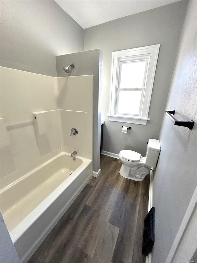 bathroom with toilet, shower / bath combination, and hardwood / wood-style flooring