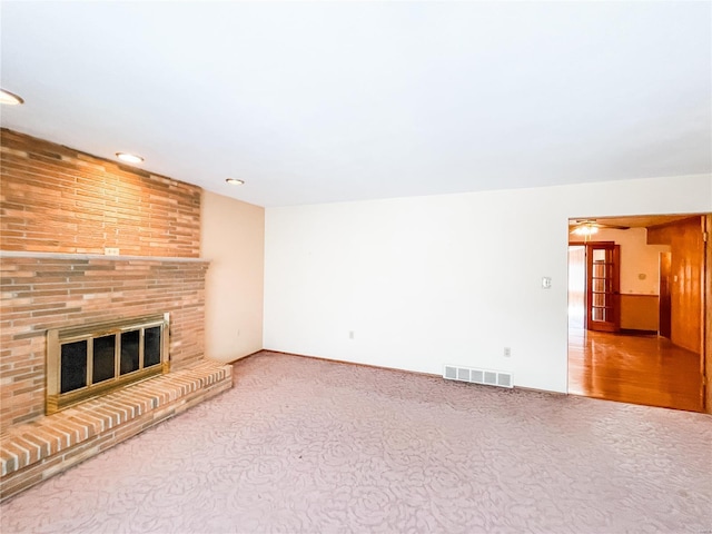 unfurnished living room with carpet floors and a fireplace