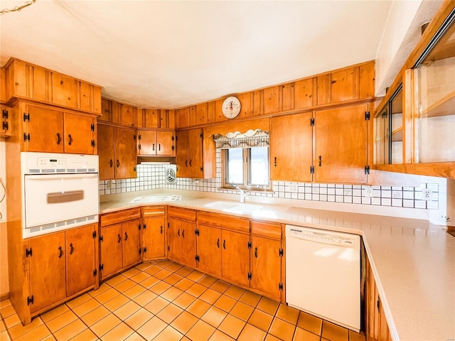 kitchen featuring sink, white appliances, decorative backsplash, and light tile patterned floors