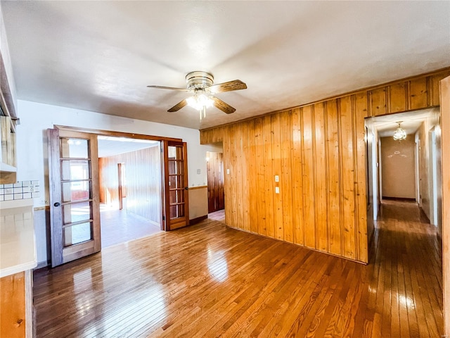 spare room featuring wooden walls, dark hardwood / wood-style floors, and ceiling fan