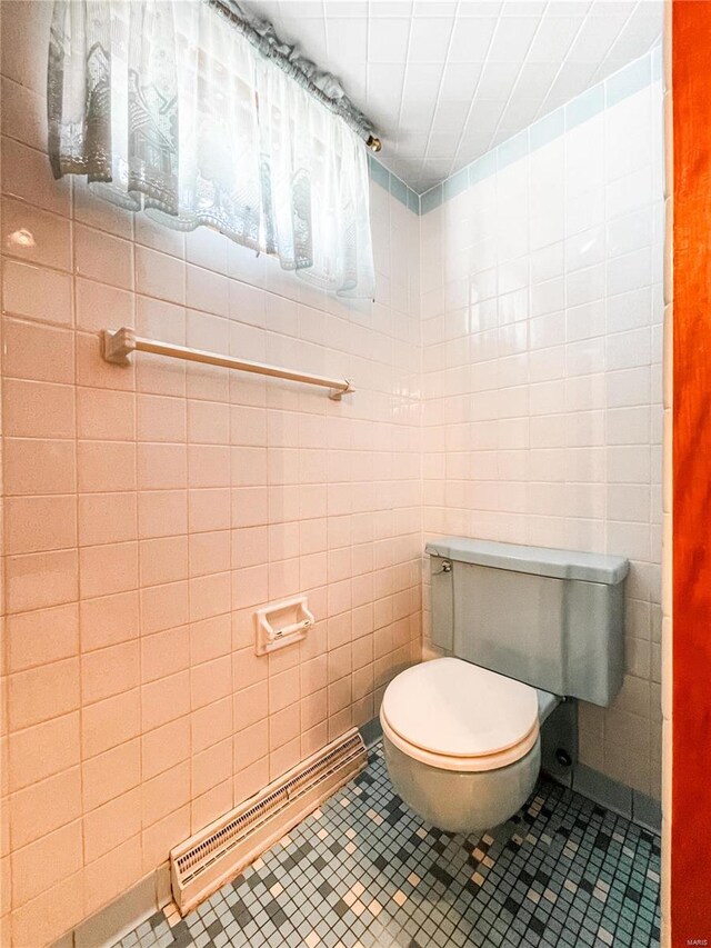 bathroom with tile walls, tile patterned floors, and toilet