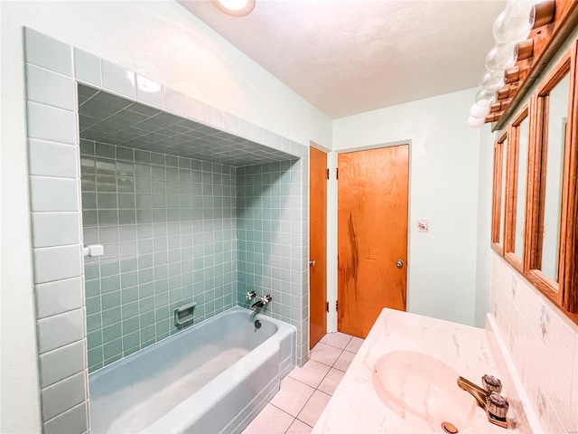 bathroom featuring tile patterned floors, tiled shower / bath combo, and vanity