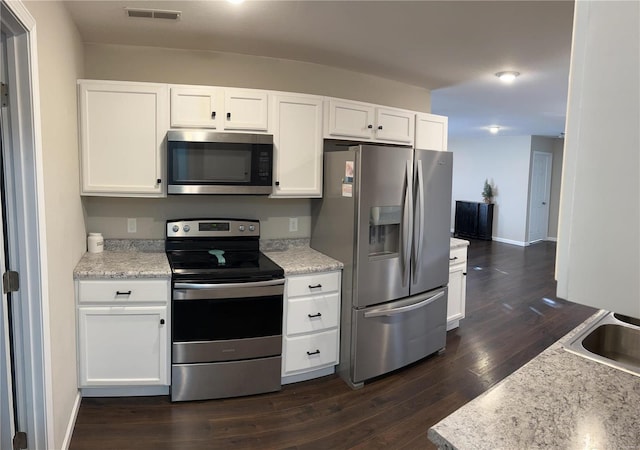 kitchen featuring light stone countertops, stainless steel appliances, dark hardwood / wood-style flooring, white cabinets, and sink