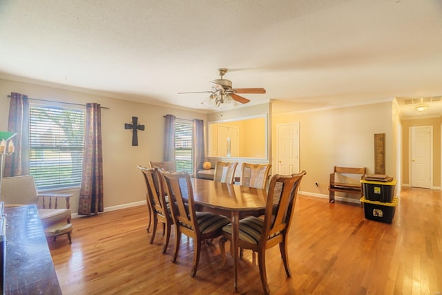 dining room featuring ceiling fan, a textured ceiling, light hardwood / wood-style flooring, and crown molding