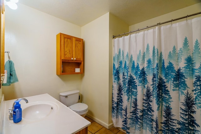 bathroom with a textured ceiling, tile patterned floors, vanity, and toilet