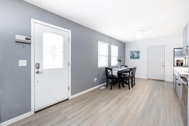 foyer with ceiling fan and light hardwood / wood-style flooring